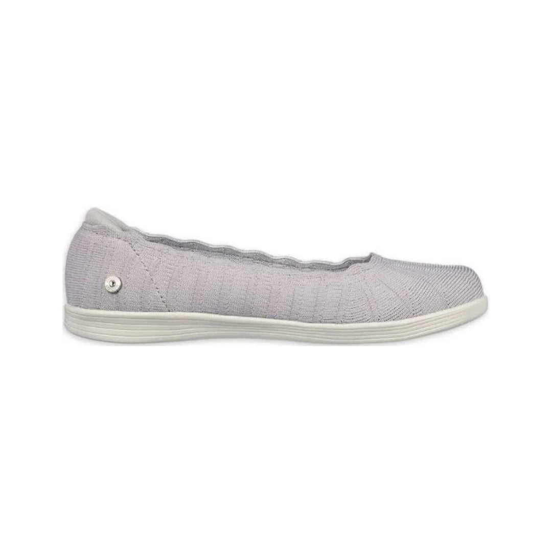 Light gray knit slip-on shoe with scalloped collar, white sole, and small metallic emblem near the heel.