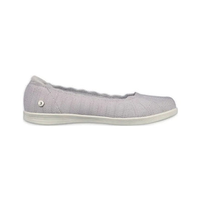 Light gray knit slip-on shoe with scalloped collar, white sole, and small metallic emblem near the heel.